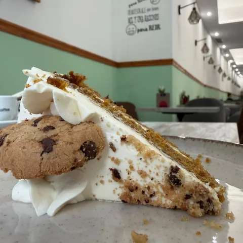 Porción de tarta choco zanahoria con nata y una cookie