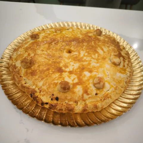 Empanada grande dorada sobre bandeja