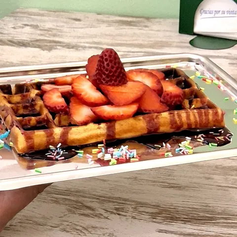 Gofre con fresas, chocolate y virutas de colores