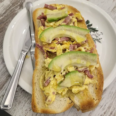Tostada revoltosa con huevos revueltos, bacon y aguacate